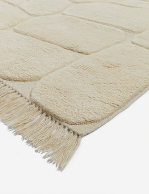 Close corner view of the Kivi raised cobblestone pattern fringe wool area rug