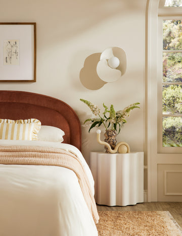 | Soft Petal matte white floral silhouette wall sconce light styled above a bedside table