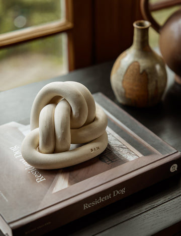 #color::bone | Decorative ceramic double coil XL Fist Knot by SIN Ceramics styled on a tabletop