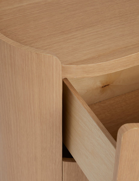 | Close up view of open drawer of the Raphael modern rounded natural wood two drawer nightstand