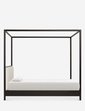 Side view of Simonette black canopy bed with upholstered headboard