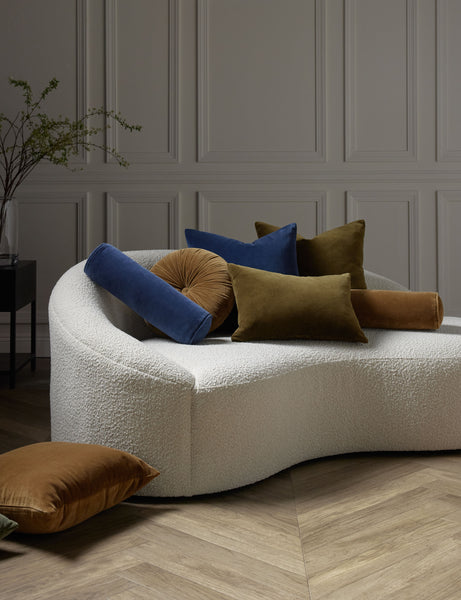 #color::true-blue #style::square | Charlotte velvet pillow in toast, olive, and true blue sit on a cream boucle lounger with other velvet pillows