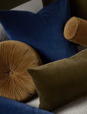Charlotte velvet pillow in olive and true blue sit on a cream boucle lounger with other velvet pillows
