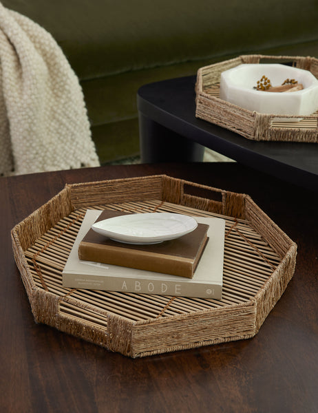 | The woven geometric bamboo murai trays sit in a living room atop nested coffee tables with decorative bowls and books stacked within them