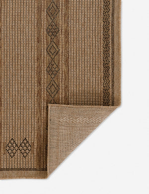 Close-up of the folded corner on the Ember brown patterned flatweave indoor and outdoor rug