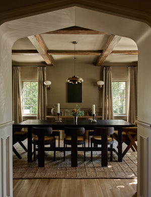 The Harper rug lays in a brown dining room under brown dining chairs and a dark brown rectangular dining table