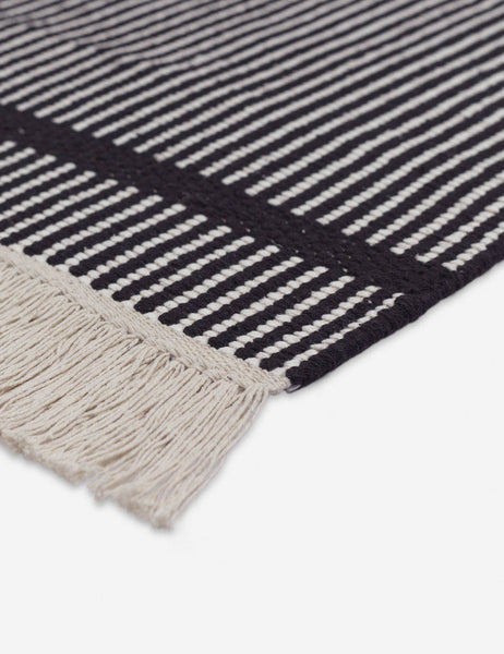 #size::1-9--x-2-10- #size::2--x-5- | Close-up of the thick fringe on the Ines handwoven black-and-white striped mat