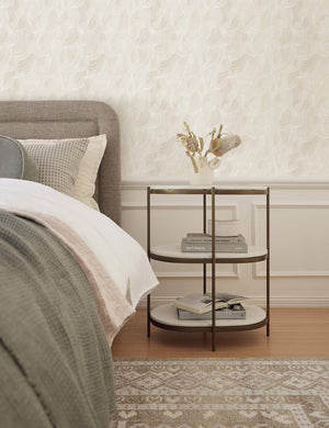 Alina neutral Wallpaper with smooth ripple pattern is in a bedroom with olive linens and a three-tiered nightstand