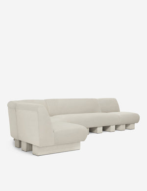 Angled view of the Lena left-facing white boucle sectional sofa with upholstered beam legs.