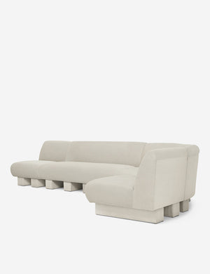 Angled view of the Lena right-facing white boucle sectional sofa with upholstered beam legs.
