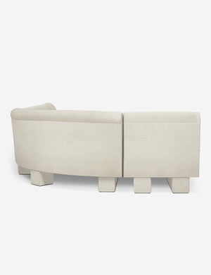 Rear view of the side of the Lena left-facing white boucle sectional sofa with upholstered beam legs.