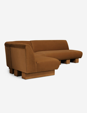 Angled view of the Lena left-facing cognac velvet sectional sofa with upholstered beam legs.