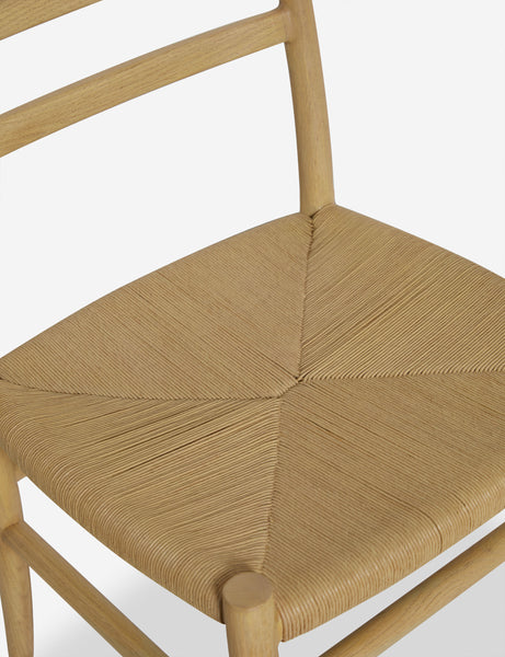 #color::natural-oak | Close up view of the Nicholson slim natural oak wood frame and woven seat dining chair.
