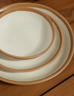 The soup bowl, appetizer plate, and entree plate part of the Tara Melamine and bamboo white 12-piece dinnerware set stacked onto each other