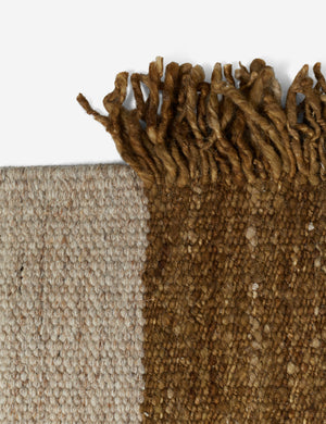 The fringe edge on the brown portion and the fringeless edge on the natural portion of the wilcox rug