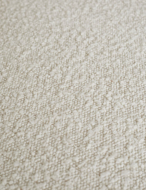 Close-up of the white boucle fabric on the Celeste honey wood accent chair with wishbone frame