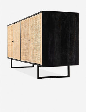 Angled side view of the Hannah black mango wood sideboard with cane doors and an iron base.