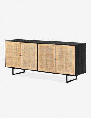Angled view of the Hannah black mango wood sideboard with cane doors and an iron base.