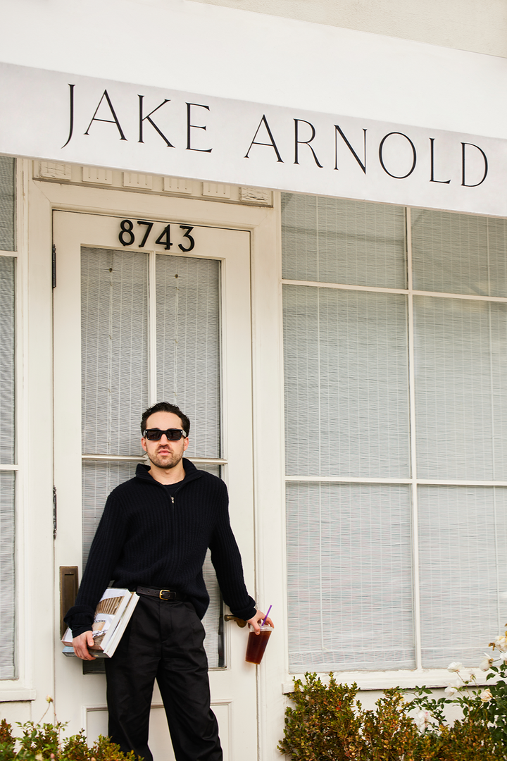 Designer Jake Arnold poses in front of the door to his Los Angeles office space.