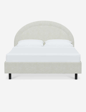 Odele White Boucle upholstered bed with an arched headboard that has a welted border