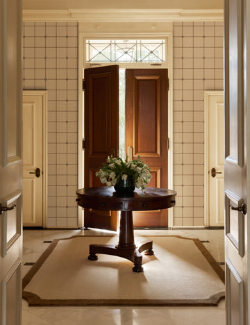 #color::ivory | A foyer featuring the Caraby grid pattern Wallpaper by Jake Arnold