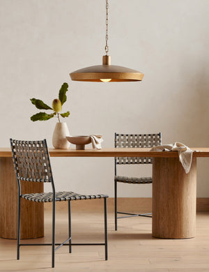 Kamlyn shallow hammered metal dome pendant light in brass hanging over a dining table.