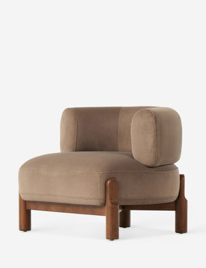 Angled view of the Furst sculptural upholstered barrel back accent chair in taupe velvet.