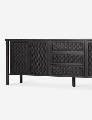 Close up view of the Isaura black cane-paneled media console.