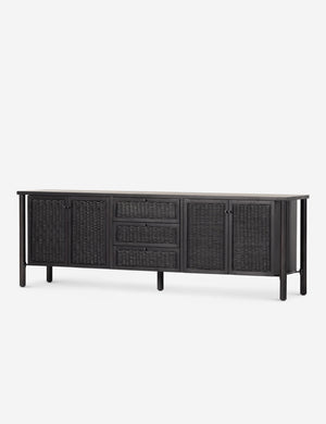 Angled view of the Isaura black cane-paneled media console.