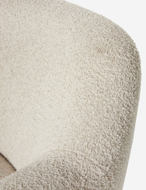 Close up view of the fabric texture of the Selkie modern barrel swivel chair in ivory boucle.