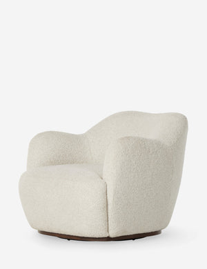 Angled view of the Selkie modern barrel swivel chair in ivory boucle.