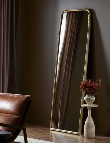 #color::gold | Coudray serpentine gold leaf frame floor mirror leaning against a wall