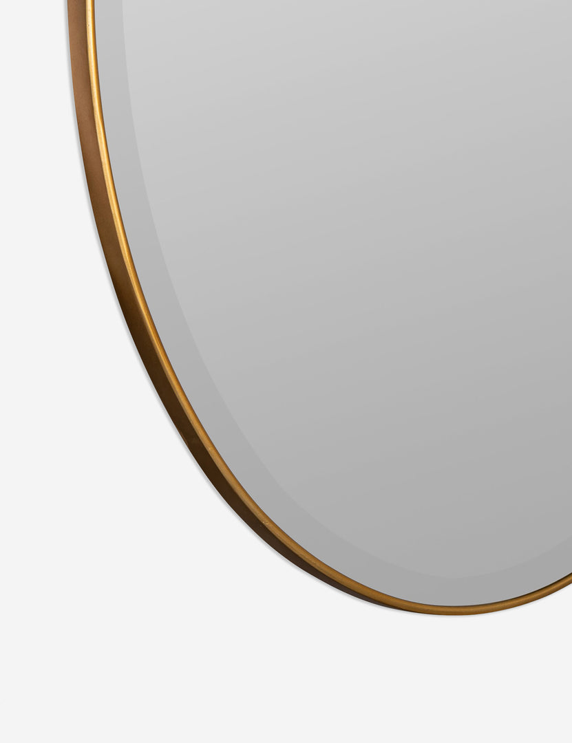 #color::gold | Close-up of the subtle bevel and thin golden frame on the Luke oval mirror