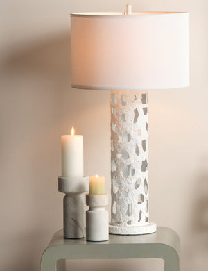Maris sculptural modern pillar candle holder styled next to a table lamp on a side table.