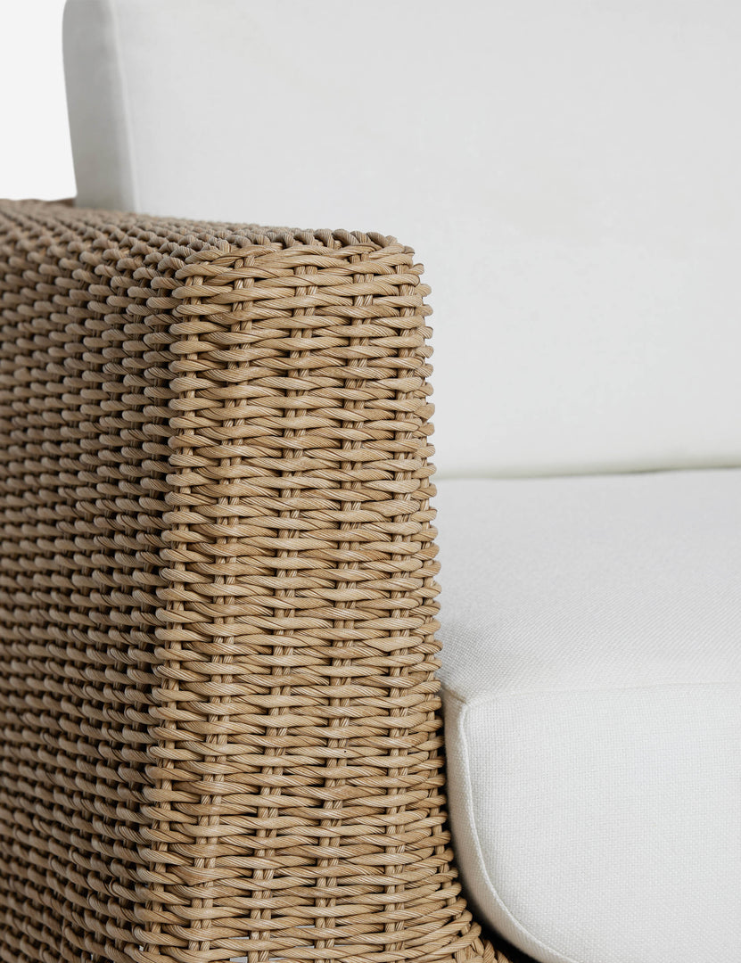 #color::natural | Close up of the arm of the Aisha wide arm modern wicker outdoor swivel chair.