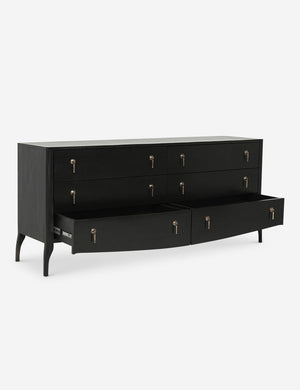 Angled view of the Anabella black wood dresser with silver drawer pulls with its bottommost drawer open