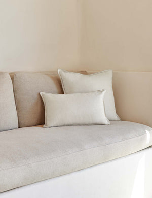 The arlo Ivory flax linen pillow in its lumber and square sizes sit together on a natural linen sofa