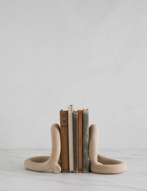 The Bacchus natural speckled ceramic bookends by sin with books in between them