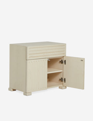Back of the Beck grooved light wood nightstand with one door open..