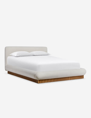 Angled view of the Billow overstuffed boucle upholstered bed with wooden base