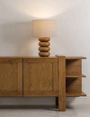Linus sculptural natural oak base table lamp styled on a sideboard cabinet.