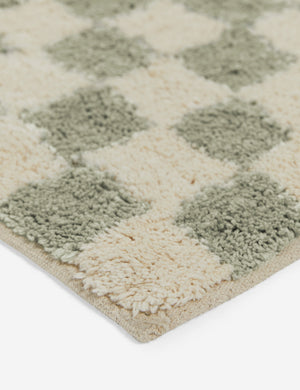 Close up corner view of the Two-tone checkerboard bath mat by Sarah Sherman in lichen green