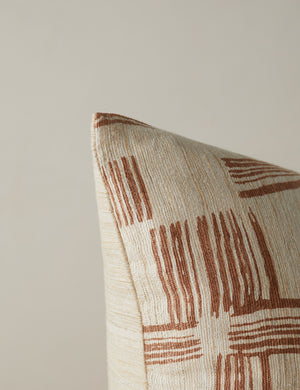 Corner of the Crossmarks Silk Pillow by Elan Byrd in terracotta.