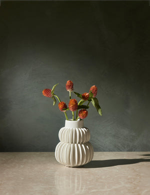 Delilah white ceramic vase featuring two rows of half-moon discs fanned around a tapered body with flowers inside of itDelilah white ceramic vase featuring two rows of half-moon discs fanned around a tapered body with flowers inside of it