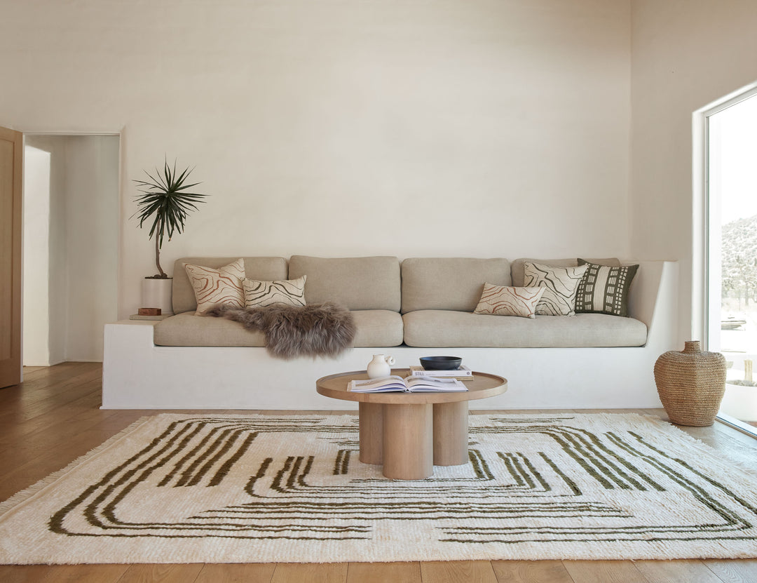 Elan Byrd rug in living room with a white frame sofa and small round coffee table