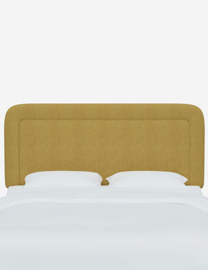 Gwendolyn Golden Linen headboard with soft, arched corners and an interior welt border