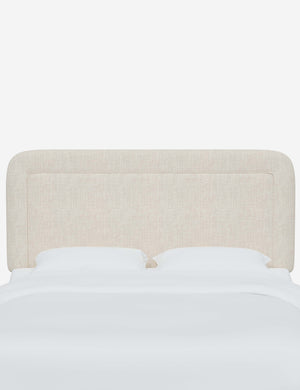Gwendolyn Talc Linen headboard with soft, arched corners and an interior welt border