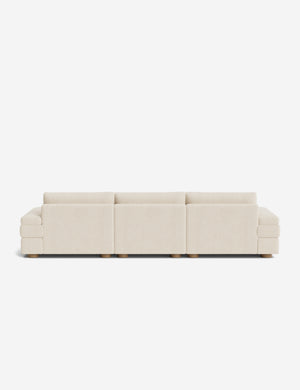 Long modular cream sectional sofa with three seat sections, low back cushions, and wooden block feet.