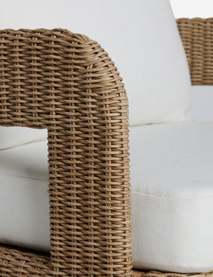 Close up of the arm of the Hadler modern sculptural open frame wicker outdoor accent chair.