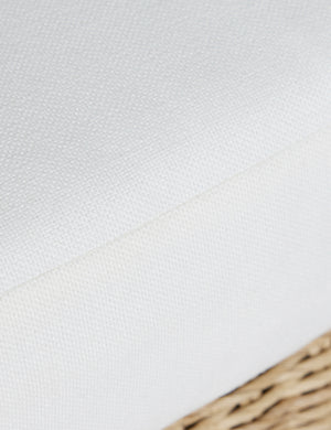 Close up of the seat cushion of the Hadler modern sculptural open frame wicker outdoor accent chair.